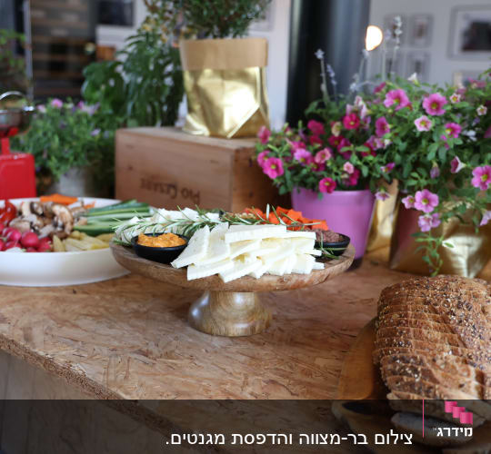 מגש ירקות, גבינות ולחם על שולחן עץ באירוע